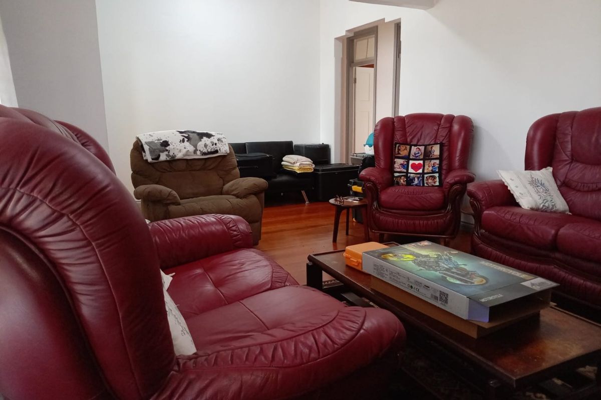 A living room featuring hardwood flooring and a classic archway leading to an adjacent space.