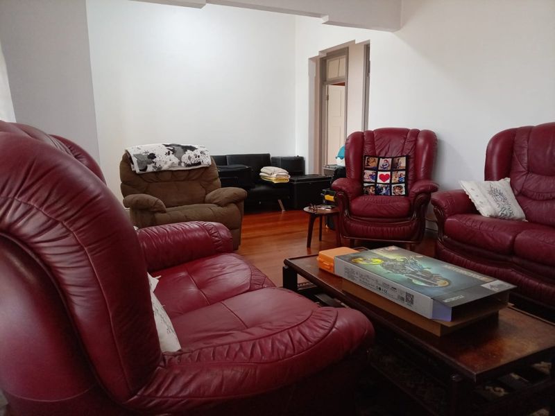 A living room featuring hardwood flooring and a classic archway leading to an adjacent space.