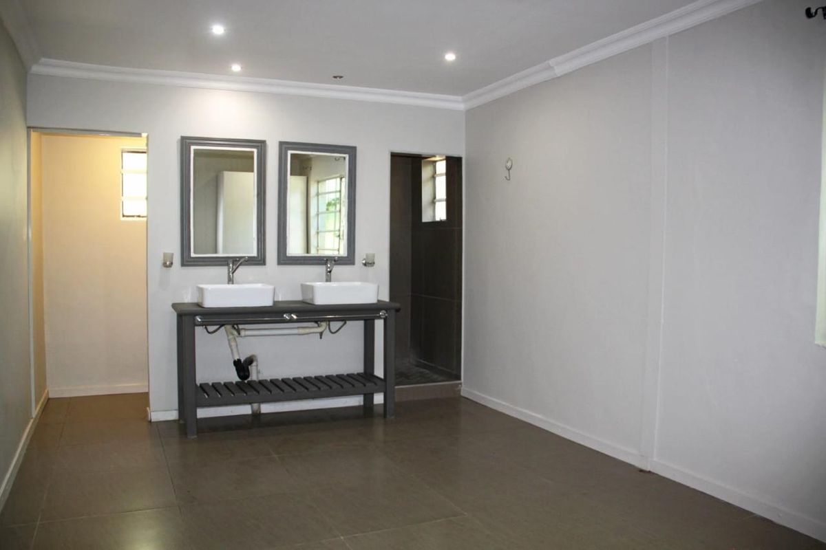 Spacious bathroom featuring a double vanity with vessel sinks, tiled flooring, and recessed lighting, offering a clean and functional layout.