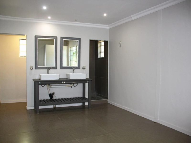 Spacious bathroom featuring a double vanity with vessel sinks, tiled flooring, and recessed lighting, offering a clean and functional layout.