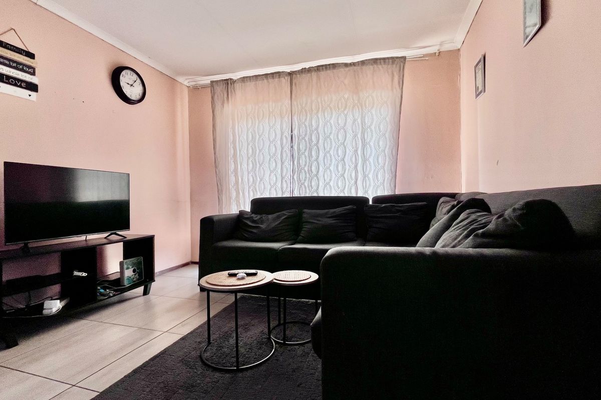 A living room featuring tiled flooring and neutral wall finishes, providing a functional and comfortable space for relaxation.