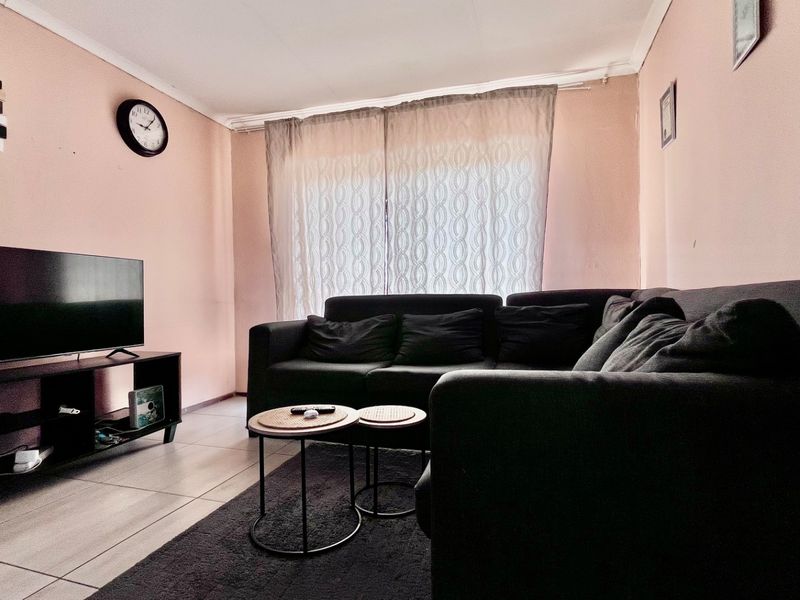 A living room featuring tiled flooring and neutral wall finishes, providing a functional and comfortable space for relaxation.