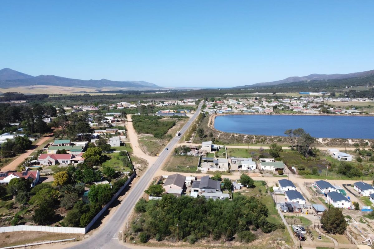 An aerial view of the residential area showing the surrounding landscape, local road network, and nearby lake.