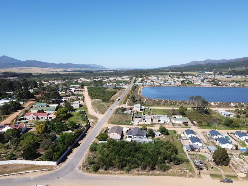 An aerial view of the residential area showing the surrounding landscape, local road network, and nearby lake.