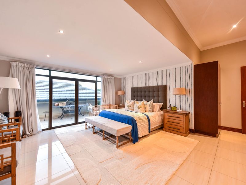 Spacious bedroom featuring tiled flooring, recessed lighting, and large sliding glass doors providing access to an outdoor balcony area.