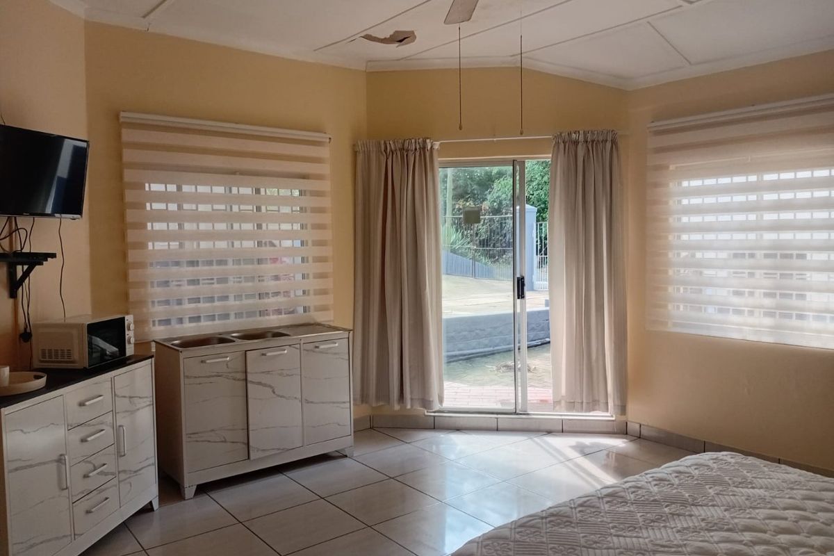 Bedroom featuring tiled flooring, a ceiling fan, and sliding glass doors providing access to the exterior area.