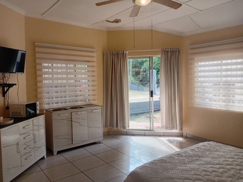 Bedroom featuring tiled flooring, a ceiling fan, and sliding glass doors providing access to the exterior area.