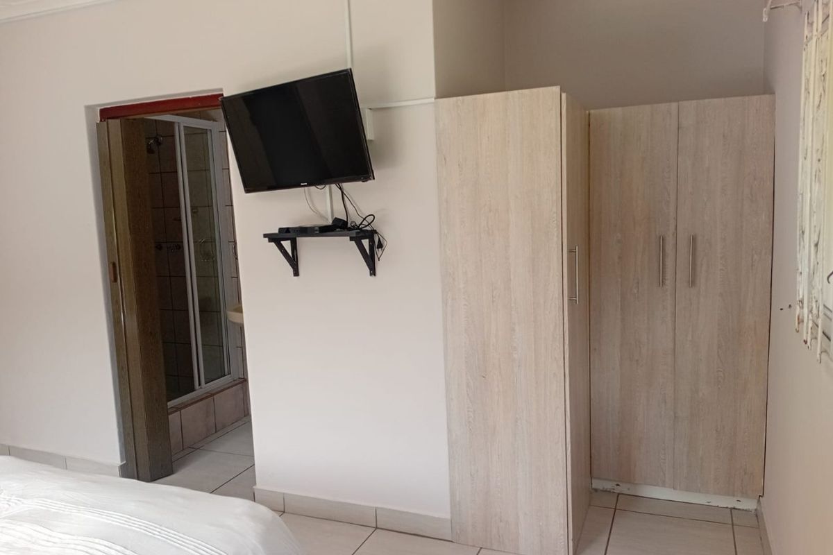Bedroom featuring tiled flooring, built-in wardrobe storage, and direct access to an en-suite bathroom.