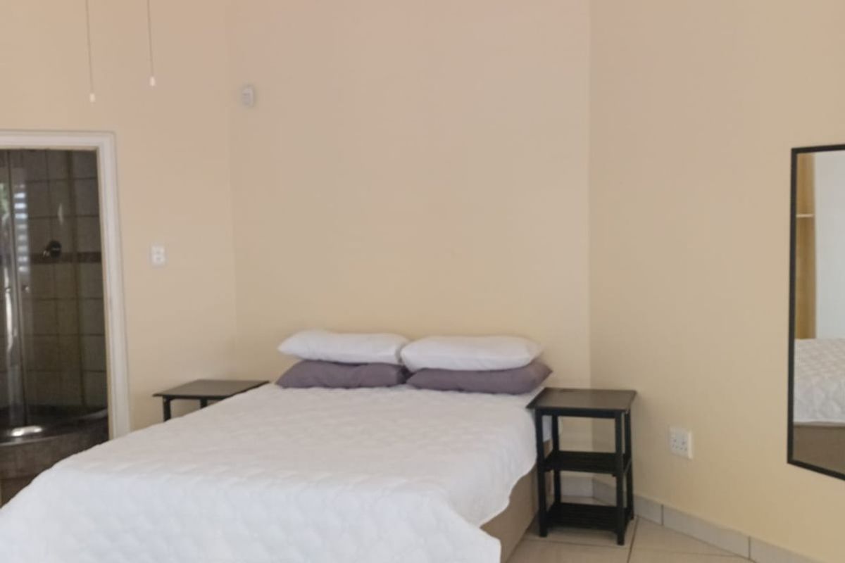 A bedroom featuring tiled flooring, a ceiling fan, and direct access to an en-suite bathroom.