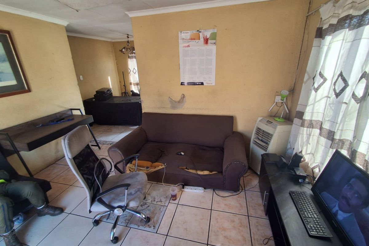 A living room space featuring ceramic floor tiles and ceiling cornicing, currently requiring significant maintenance and cosmetic updates to improve the overall condition.