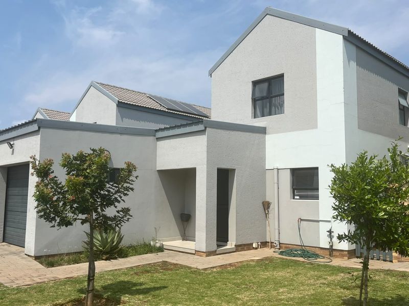 A modern double-story residential home featuring a paved driveway, integrated garage, and a well-maintained front garden area.