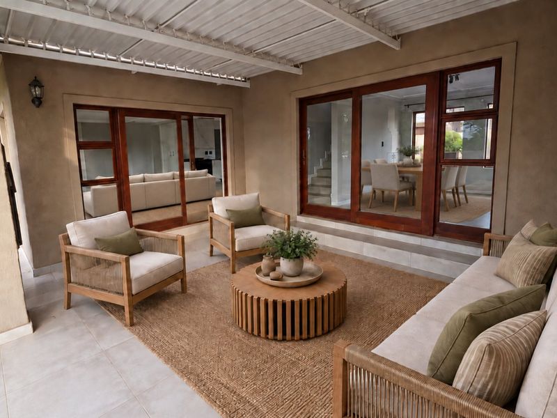 A spacious covered patio featuring tiled flooring and large timber-framed sliding doors that provide seamless access to the interior living and dining areas.