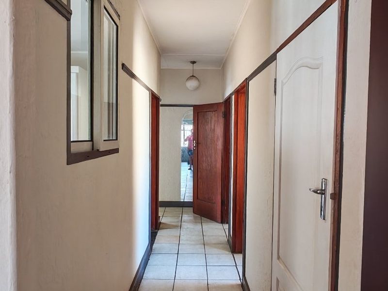A functional hallway featuring tiled flooring, multiple internal doors, and a ceiling light fixture, providing access to various rooms within the apartment.