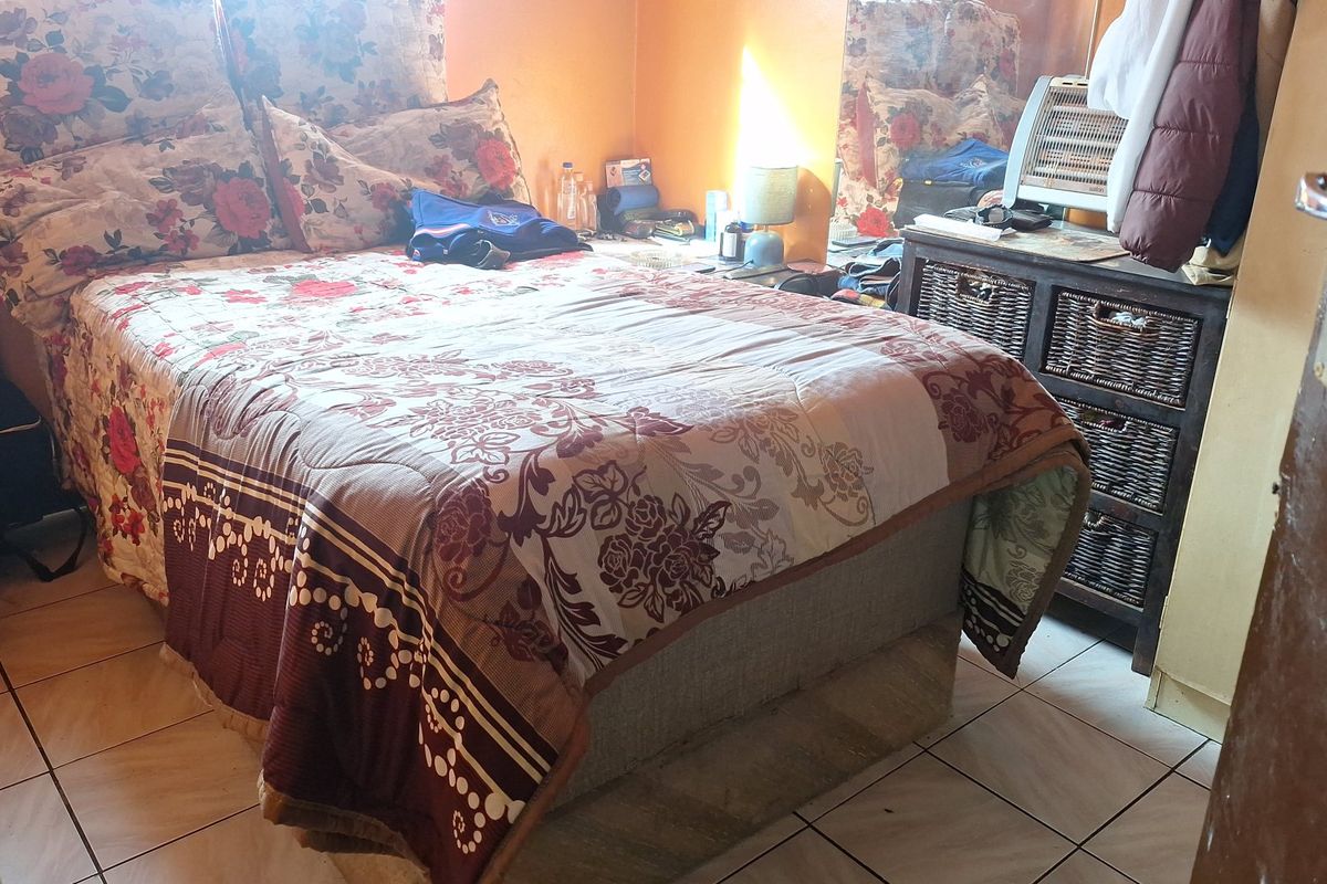 A bedroom featuring tiled flooring and orange-painted walls.