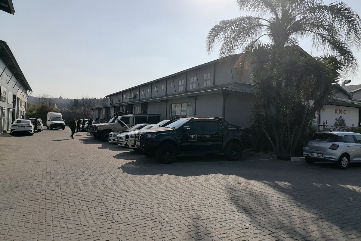 Exterior view of a commercial industrial property featuring a paved parking area and building facade.