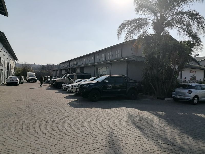 Exterior view of a commercial industrial property featuring a paved parking area and building facade.