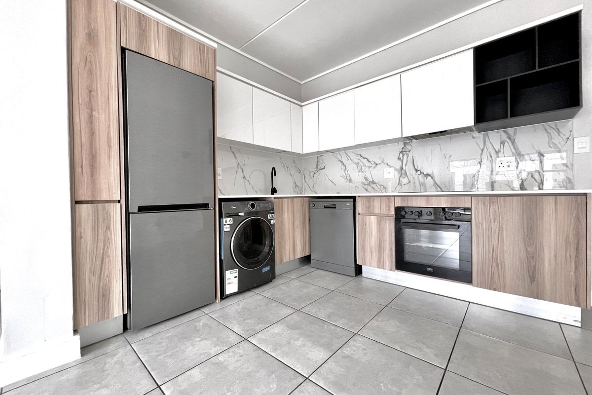 Modern kitchen featuring wood-grain and white cabinetry, marble-look splashback, tiled flooring, and integrated oven with sleek contemporary finishes.