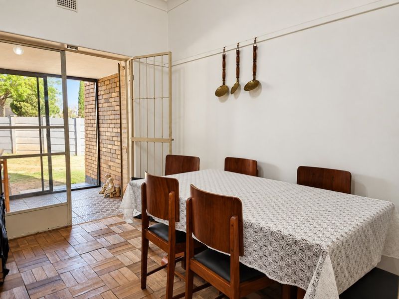 Dining room featuring classic parquet flooring and direct access to an outdoor patio area through a sliding glass door.
