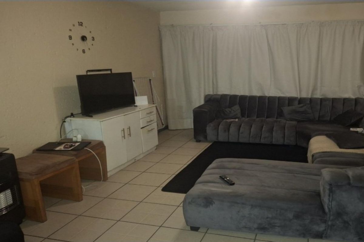 A living room area featuring tiled flooring and neutral wall finishes, providing a functional space for relaxation.