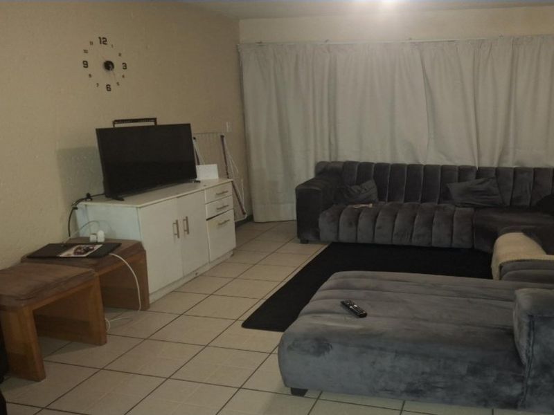 A living room area featuring tiled flooring and neutral wall finishes, providing a functional space for relaxation.