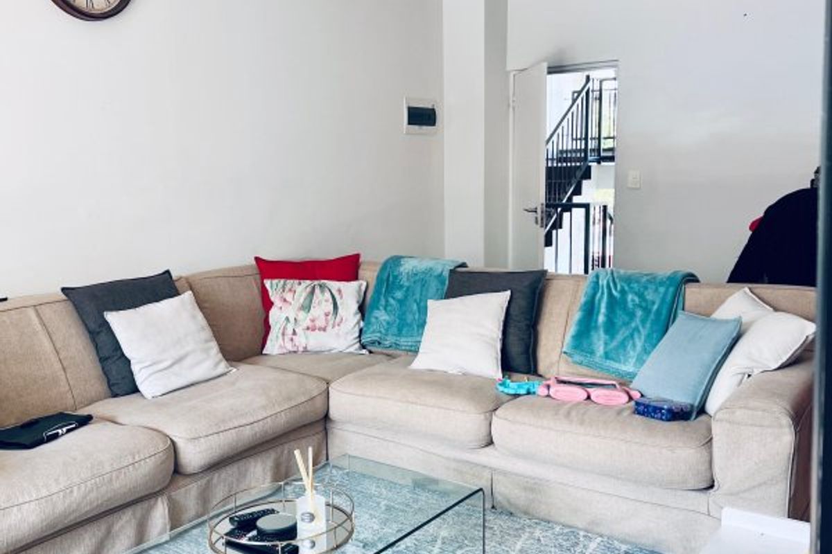 A comfortable living room area featuring neutral wall finishes and a ceiling-mounted light fixture, providing a functional space for relaxation.