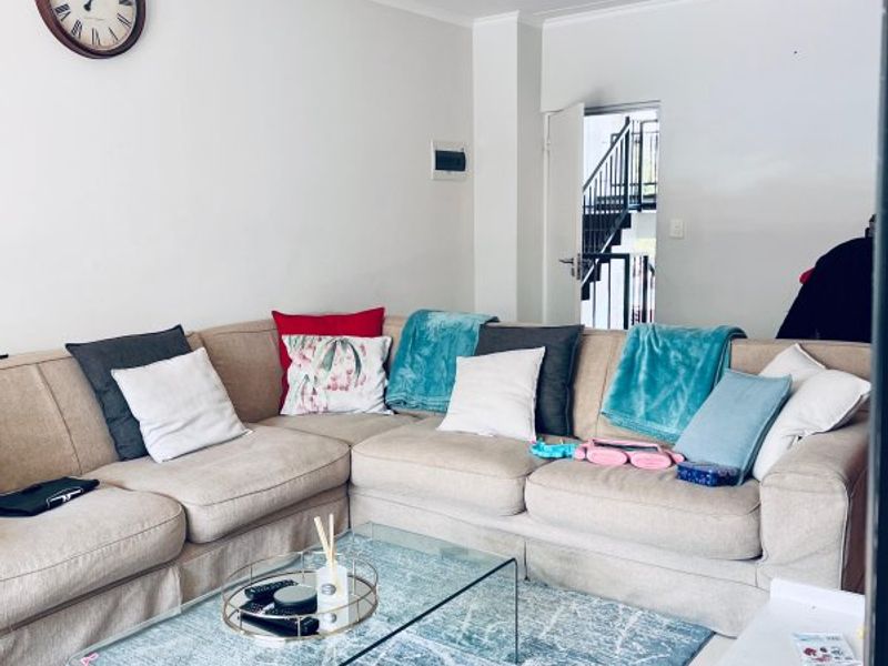 A comfortable living room area featuring neutral wall finishes and a ceiling-mounted light fixture, providing a functional space for relaxation.