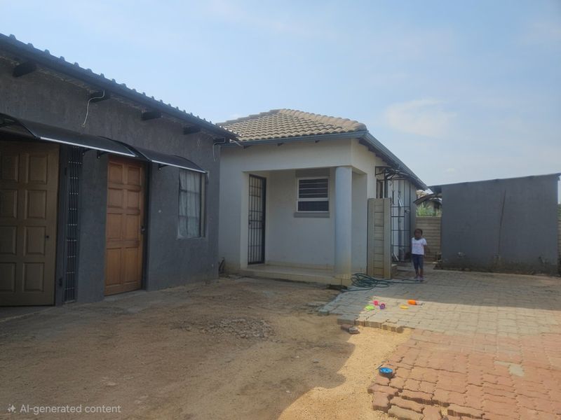 Rear exterior view of the property featuring a paved courtyard area, tiled roofing, and security access points.