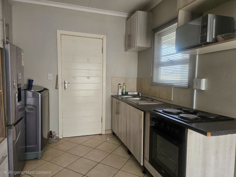 Compact kitchen featuring built-in cabinetry, laminate countertops, an electric hob, and an integrated oven with tiled flooring.