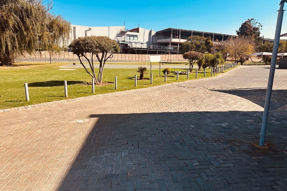 A view of the paved driveway and landscaped communal garden area at the rear of the townhouse complex.