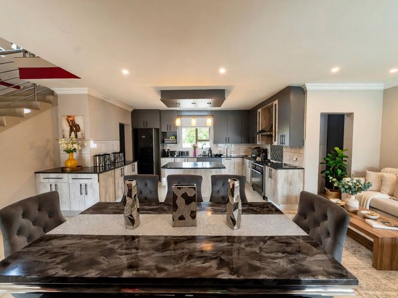 Spacious open-plan kitchen and dining area featuring modern cabinetry, a central island, and integrated appliances, seamlessly connected to the living space.