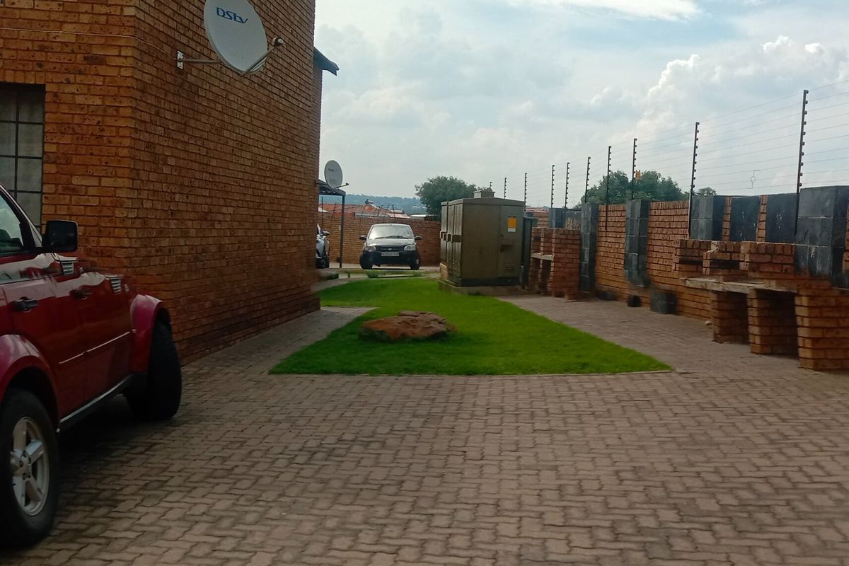 Rear exterior area featuring brick paving, a built-in brick braai, and perimeter electric fencing.