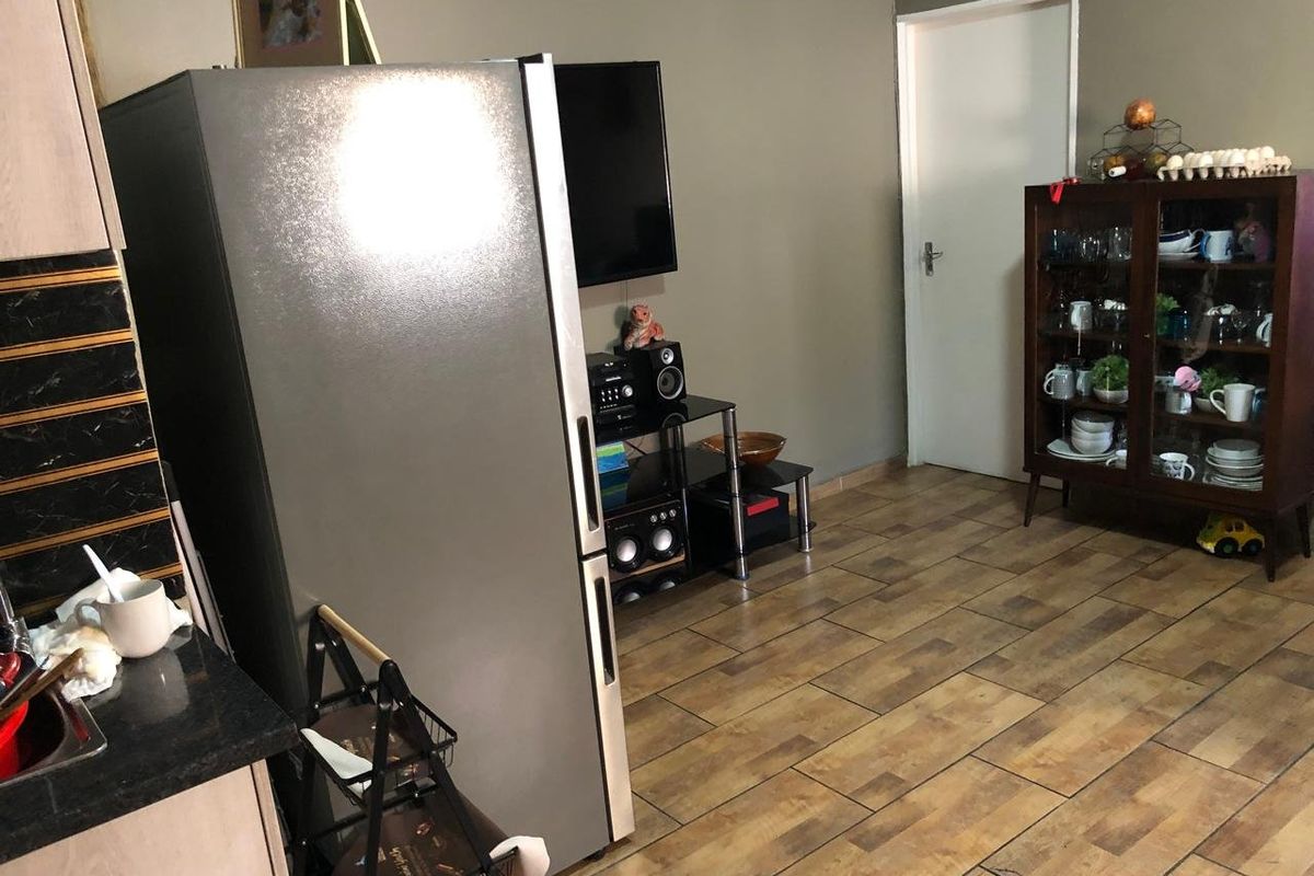 A functional kitchen area featuring tiled flooring, dark cabinetry, and granite countertops, providing a practical workspace within the home.