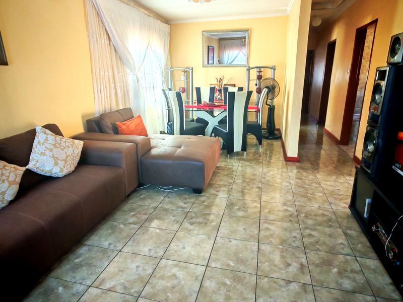 Open plan living and dining area featuring tiled flooring and neutral wall finishes, providing a functional space for daily living.
