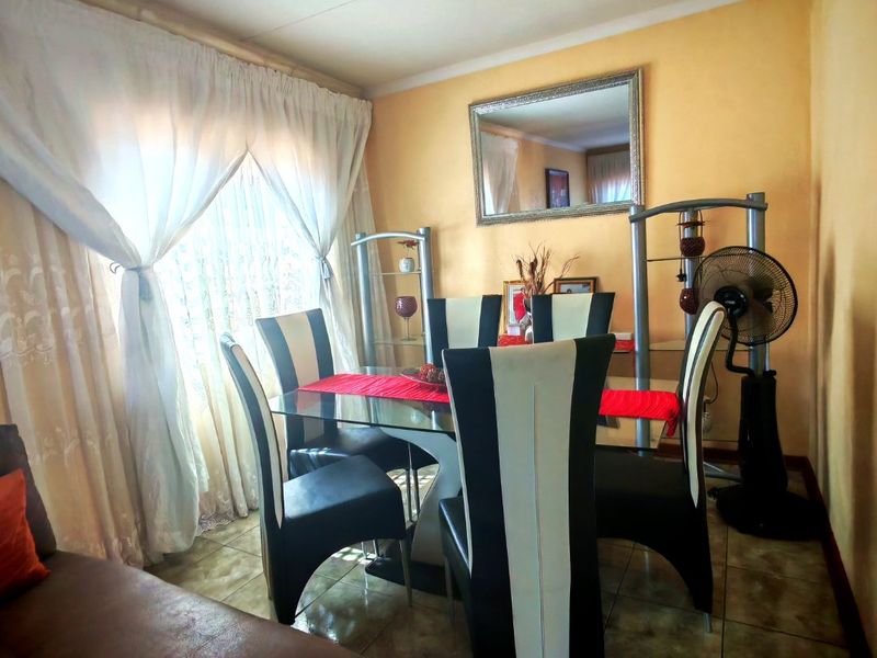 A dining room area featuring tiled flooring and window treatments, providing a functional space for meals.