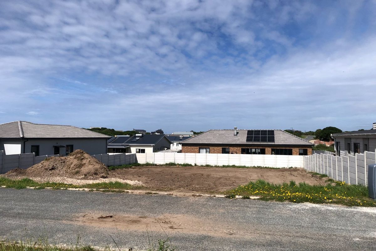 A vacant residential plot featuring a level surface, enclosed by precast concrete boundary walls, situated in a developed neighborhood.