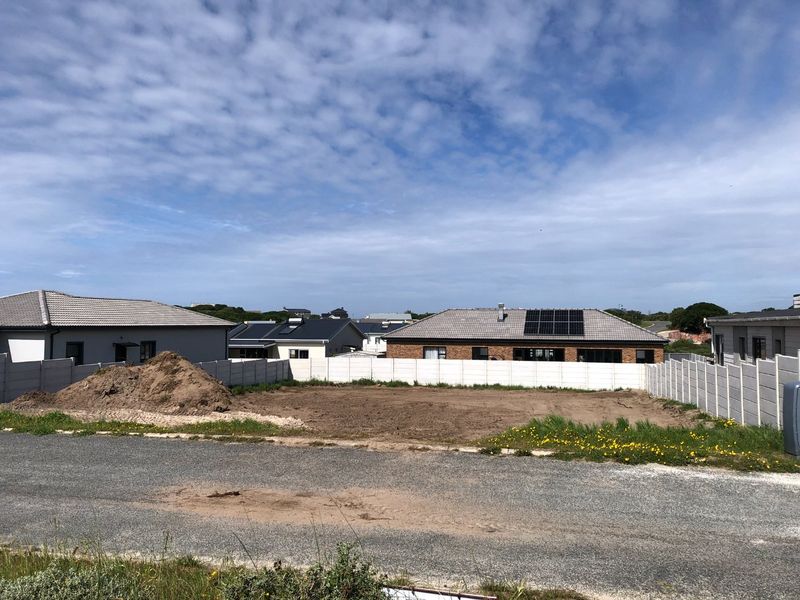 A vacant residential plot featuring a level surface, enclosed by precast concrete boundary walls, situated in a developed neighborhood.
