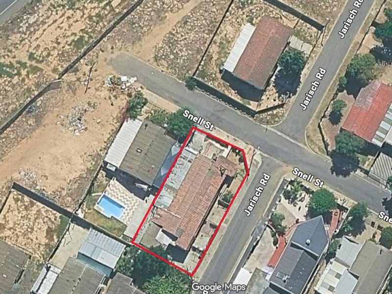 Aerial view of the property corner lot, highlighting the building footprint, roof structure, and surrounding street layout.