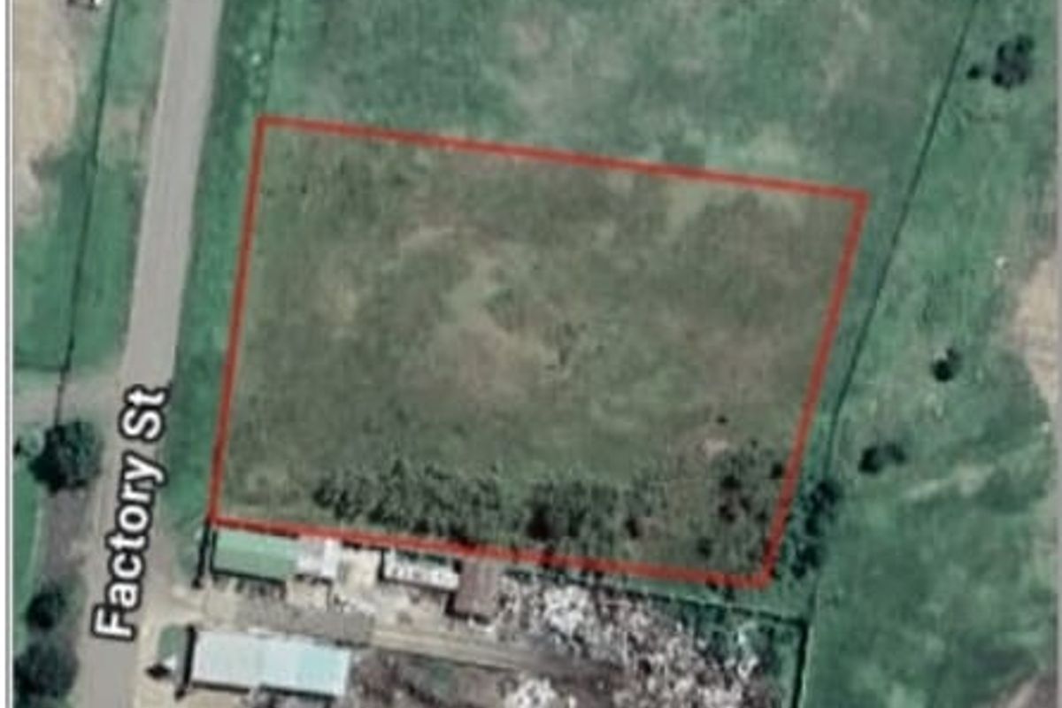 Aerial view of a vacant residential plot of land with clear boundary markings, situated adjacent to Factory Street.