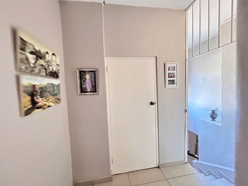 A functional hallway area featuring tiled flooring and access to a staircase, providing a central circulation point within the home.