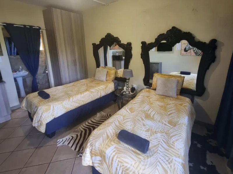 A bedroom featuring tiled flooring, a built-in wardrobe, and an integrated wash basin area, requiring cosmetic updates to improve the overall finish.