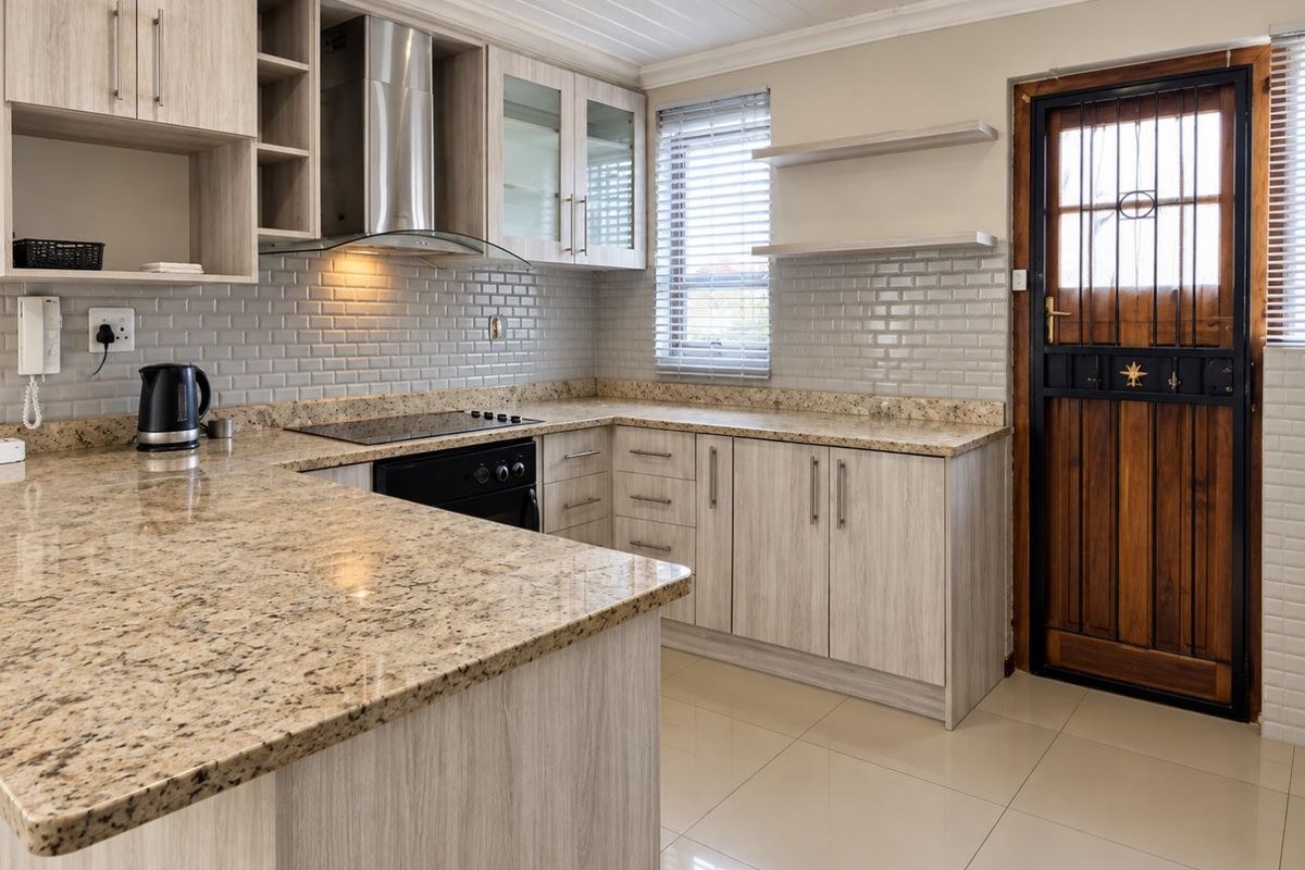 Modern kitchen featuring granite countertops, subway tile backsplash, built-in oven, electric cooktop, and timber-look cabinetry with direct access to the exterior.