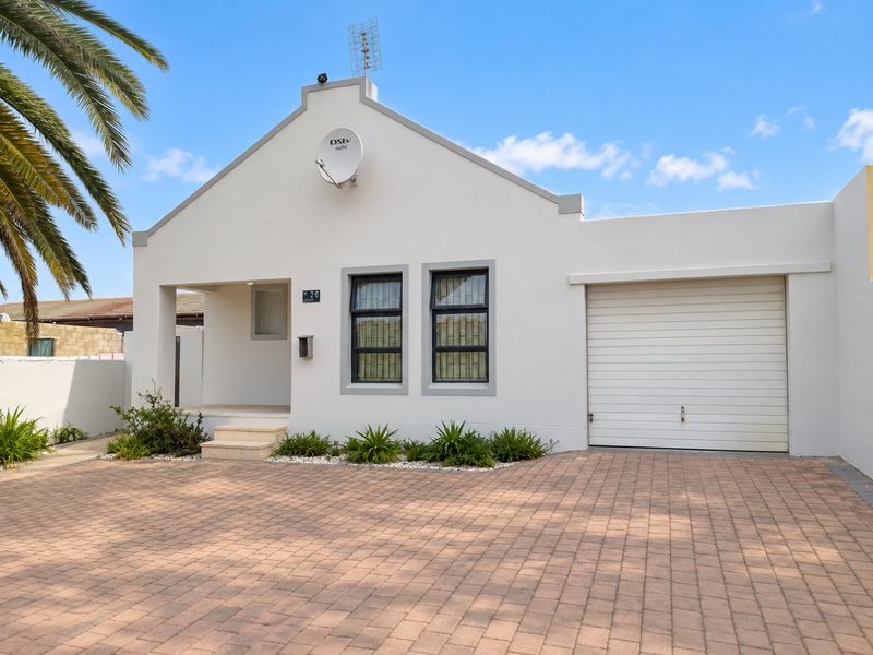 A well-maintained front elevation featuring a paved driveway, single garage, and a clean, modern facade with secure window treatments.