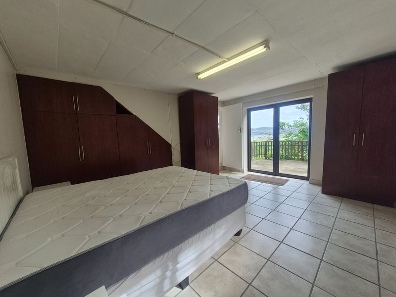 Bedroom featuring extensive built-in cabinetry, tiled flooring, and direct access to a balcony through sliding glass doors.
