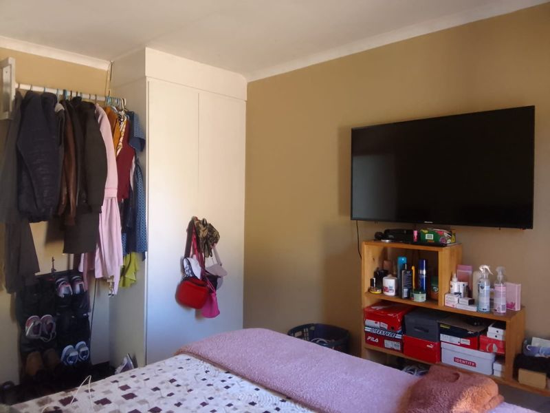 A bedroom featuring a built-in wardrobe and neutral wall finishes, providing a functional space for rest and storage.