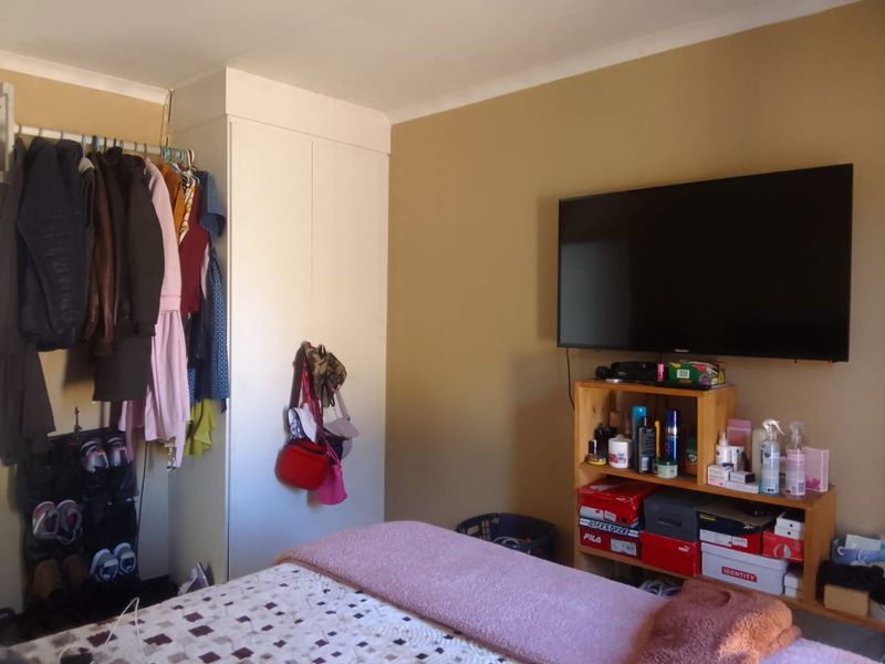 A bedroom featuring a built-in wardrobe and neutral wall finishes, providing a functional space for rest and storage.