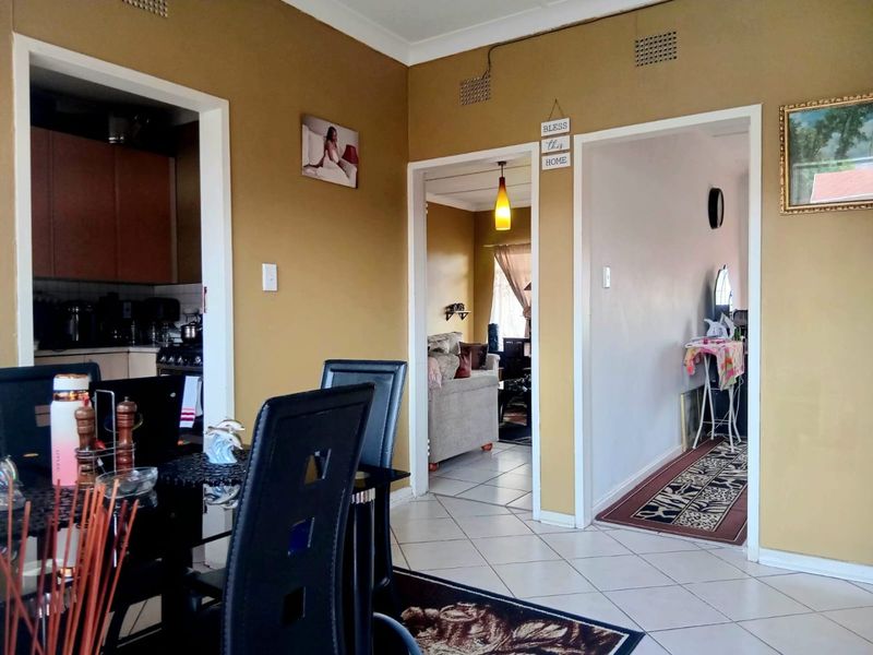 Open plan living area featuring tiled flooring and neutral wall tones, providing access to the kitchen and adjacent living spaces.