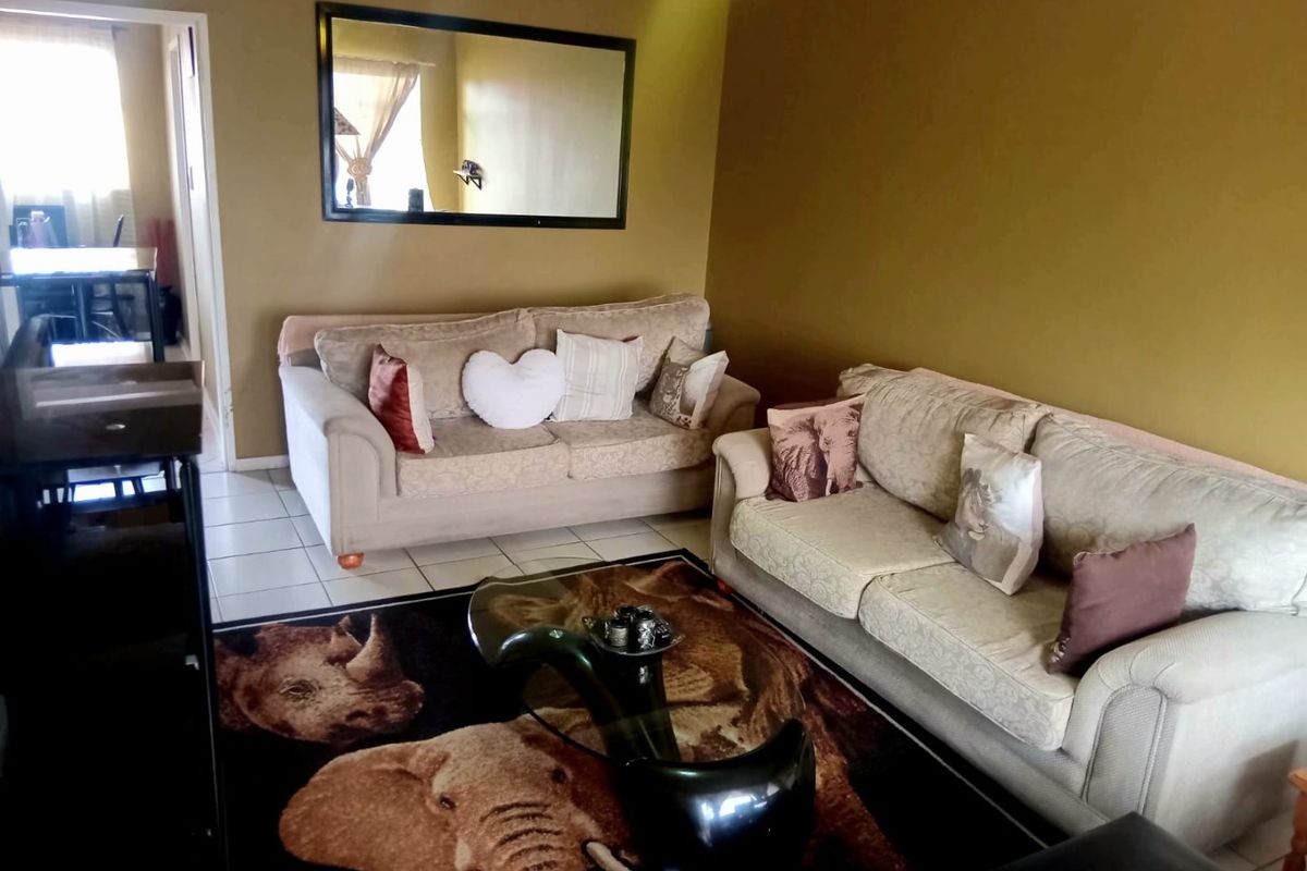 A living room area featuring tiled flooring and neutral wall tones, providing a functional space for relaxation.
