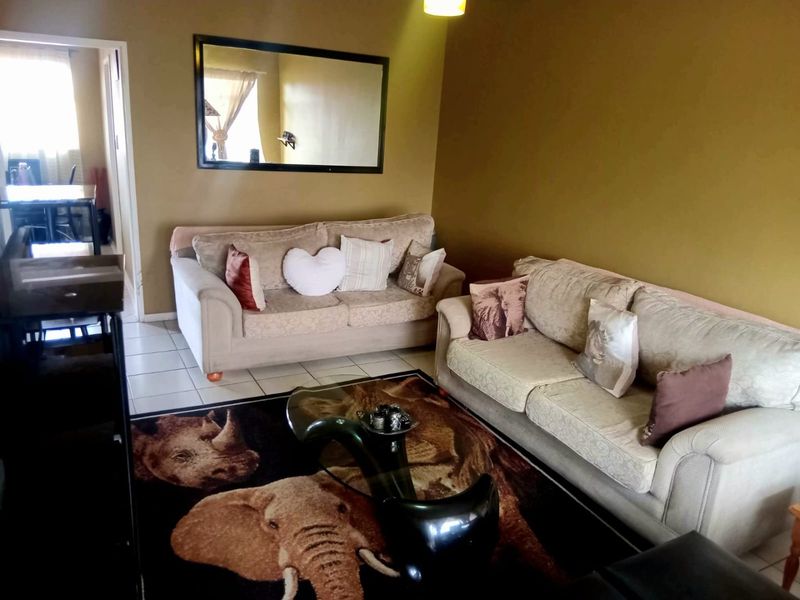 A living room area featuring tiled flooring and neutral wall tones, providing a functional space for relaxation.