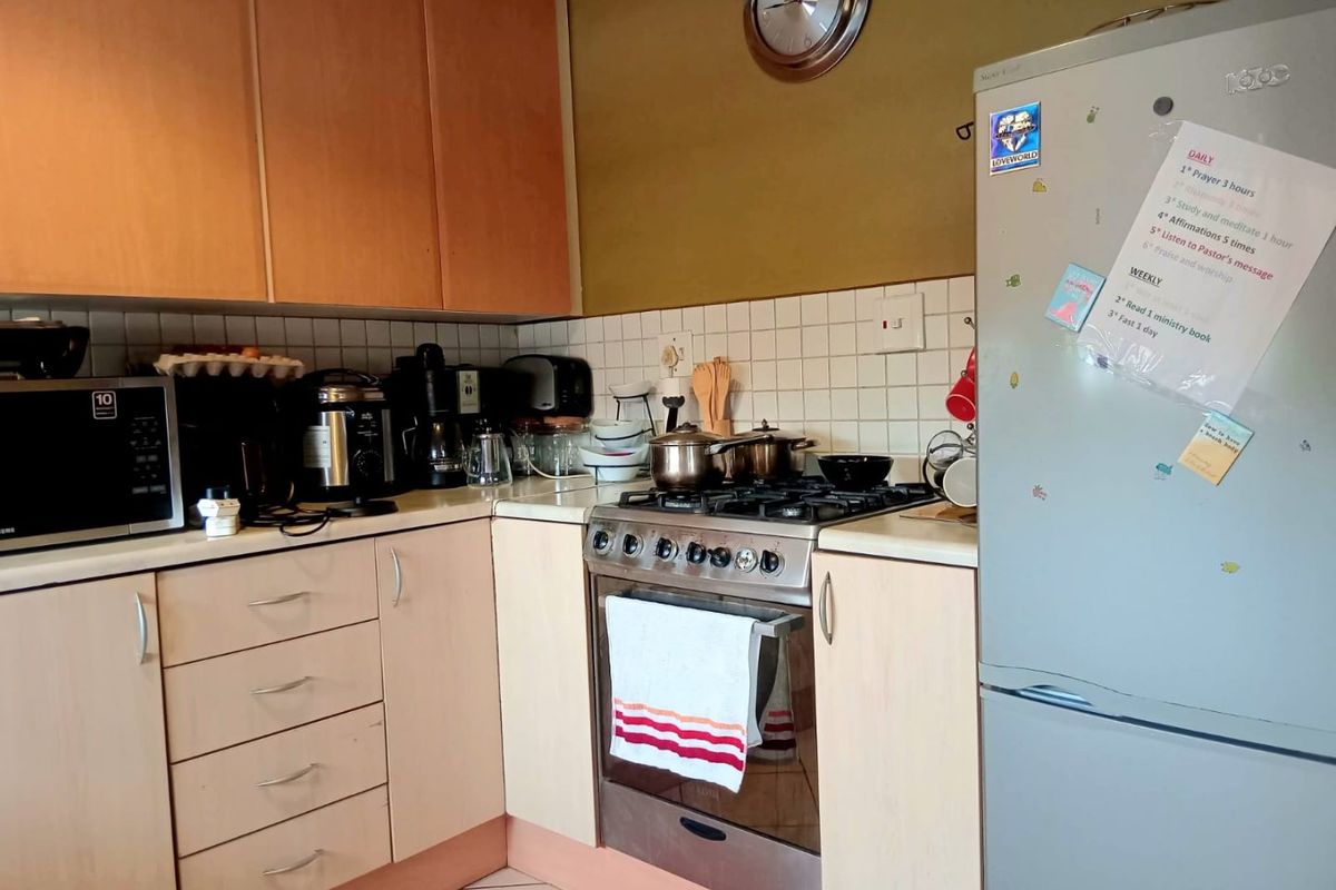 A functional kitchen featuring laminate cabinetry, a tiled backsplash, and a built-in gas hob with oven, offering a practical layout for daily cooking.