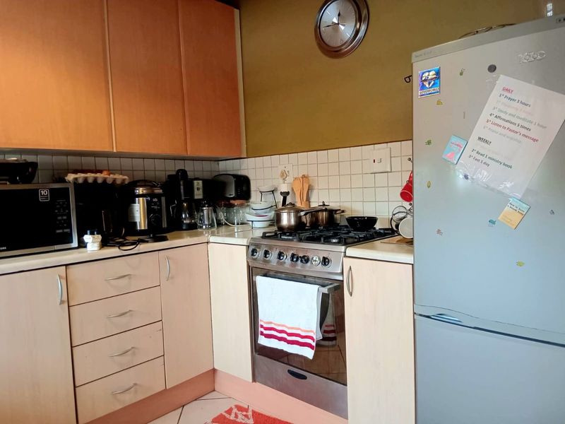 A functional kitchen featuring laminate cabinetry, a tiled backsplash, and a built-in gas hob with oven, offering a practical layout for daily cooking.